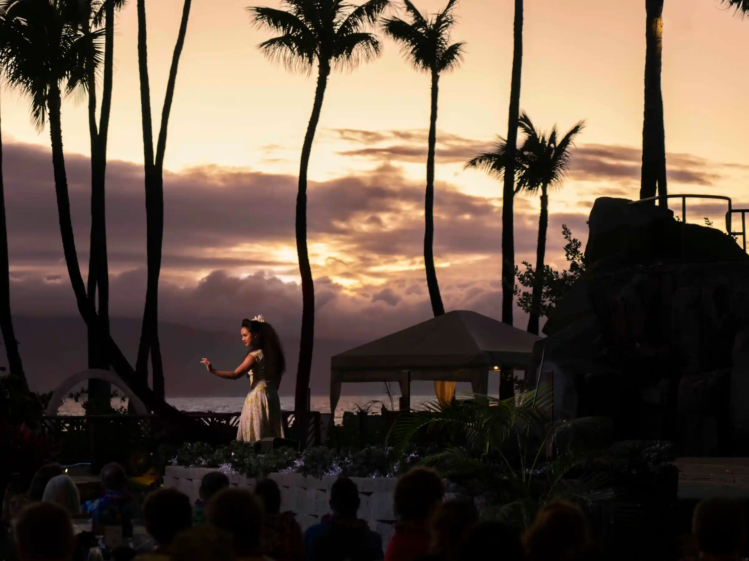 a group of people standing in front of a palm tree