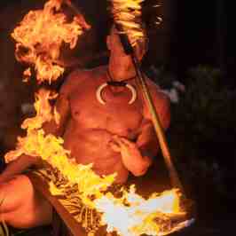 a person holding a birthday cake that is on fire